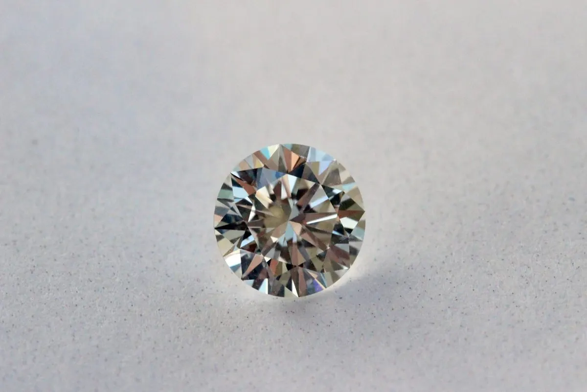 Loose round brilliant cut diamond on a light gray surface