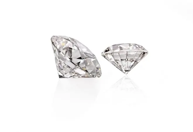 Two polished round lab grown diamonds on a white background