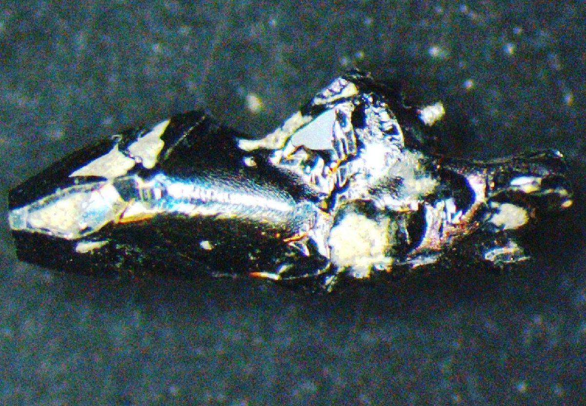 Rough crystal of silicon carbide, dark with metallic iridescent faces